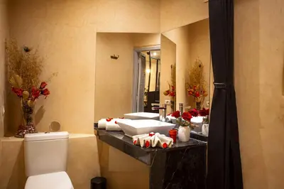 a bathroom with a toilet and a sink and a mirror at Villa Cosy Piscine Proche centre-ville 4 suites in Marrakech