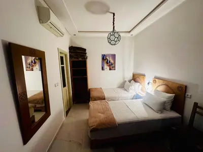 a small bedroom with two beds and a mirror at Riad hotel Cecil in Marrakech