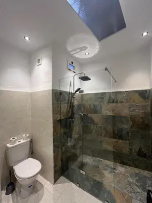a bathroom with a toilet and a glass shower at Riad Jnan El Cadi in Marrakech