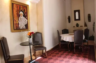 a dining room with a table and a painting on the wall at Riad Jnan El Cadi in Marrakech