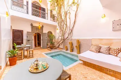 a living room with a pool and a table at Riad Coco Marrakech in Marrakech