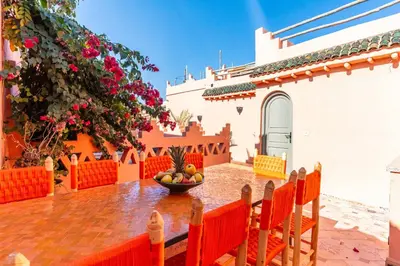a patio with a table with a bowl of fruit at Riad Coco Marrakech in Marrakech