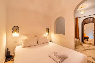 a bedroom with a bed with white sheets and pillows at Riad Coco Marrakech in Marrakech
