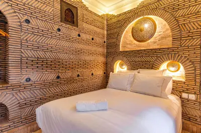 a bedroom with a large bed with a brick wall at Riad Coco Marrakech in Marrakech