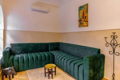 a living room with a green couch and a table at Riad Coco Marrakech in Marrakech