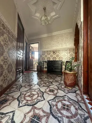 a hallway with a tile floor and a chandelier at Stylish Moroccan Apartment Near Marrakech Airport in Marrakech
