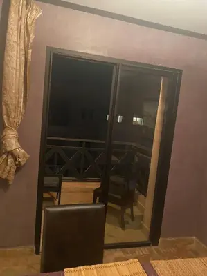 a room with a large glass door with a balcony at Appartement Ensoleillé vue Piscine in Marrakech