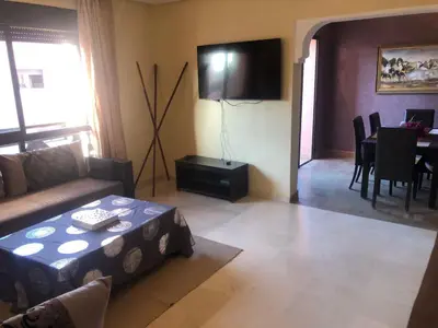 a living room with a couch and a table at Appartement Ensoleillé vue Piscine in Marrakech