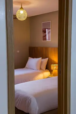 a bedroom with two beds and a chandelier at TheCasaEdition - Gueliz Apartments in Marrakech