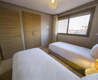 a bedroom with two beds and a window at TheCasaEdition - Gueliz Apartments in Marrakech