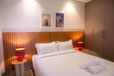a bedroom with a large white bed with two lamps at TheCasaEdition - Gueliz Apartments in Marrakech