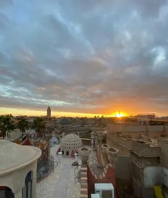 a view of a city at sunset from a building at Hostel kif kif annex in Marrakech