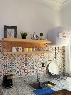 a kitchen with a sink and a tile wall at Julie's AIRPORT Apartment in Marrakech
