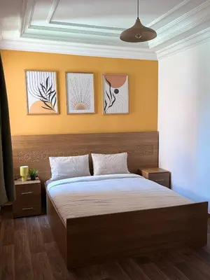 a bedroom with a bed with four pictures on the wall at Julie's AIRPORT Apartment in Marrakech