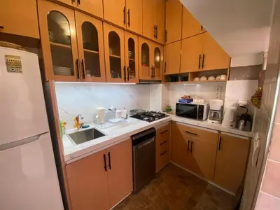 a small kitchen with wooden cabinets and a sink at Riad Dar Jdati in Marrakech