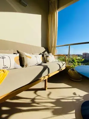 a couch sitting in a room with a window at Luxueux Appartement Prestigia in Marrakech