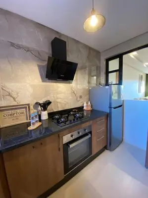 a kitchen with a stove and a refrigerator at Luxueux Appartement Prestigia in Marrakech