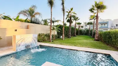 a swimming pool with a fountain in a yard with palm trees at LUXURY Villa Argane 5 BDR -ONLY FAMILYS in Marrakech