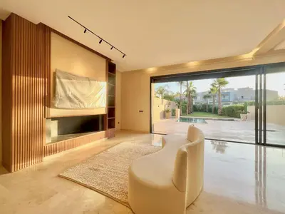 a living room with a tv and a white chair at LUXURY Villa Argane 5 BDR -ONLY FAMILYS in Marrakech