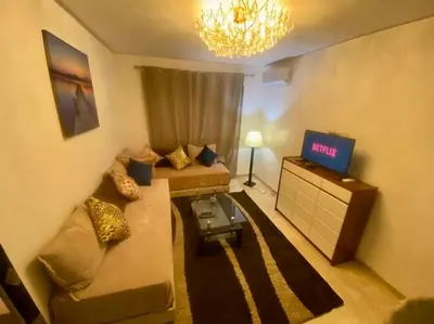 a living room with a couch and a tv at Chic & Cosy au coeur d’hivernage in Marrakech