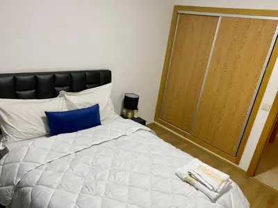 a bedroom with a large bed with a blue pillow at Chic & Cosy au coeur d’hivernage in Marrakech