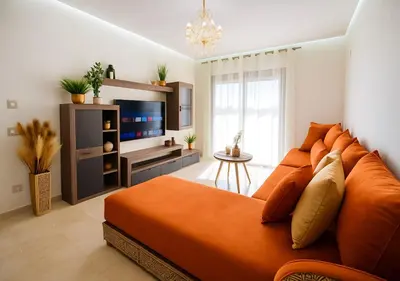 a bedroom with a large orange bed and a flat screen tv at Pearl Garden 69 in Marrakech