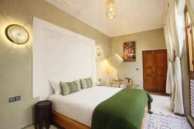 a bedroom with a large bed with a green blanket at Riad Chez Henriette in Marrakech