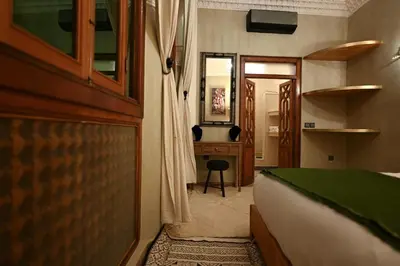 a bedroom with a bed and a desk and a mirror at Riad Chez Henriette in Marrakech