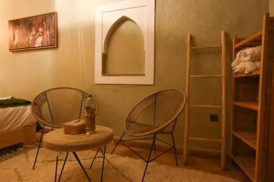 two chairs and a table in a room at Riad Chez Henriette in Marrakech