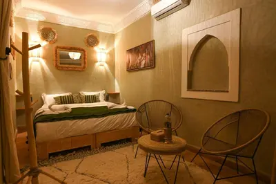 a bedroom with a bed and two chairs at Riad Chez Henriette in Marrakech