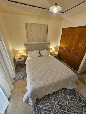 a bedroom with a large bed and two night stands at AL ANDALOUS 6 - une chambre in Marrakech