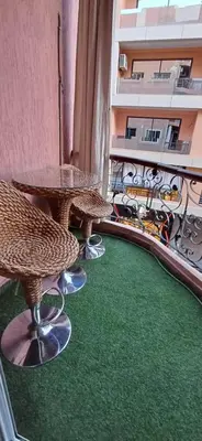 a balcony with two tables and chairs on a green floor at AL ANDALOUS 6 - une chambre in Marrakech