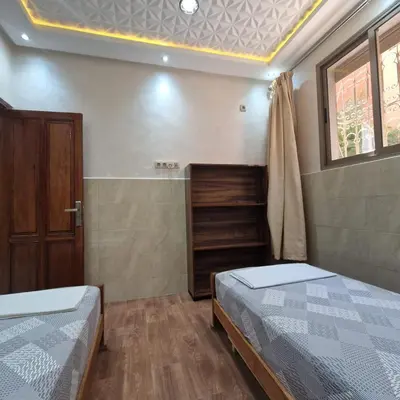 a bedroom with two beds and a window at Bel appartement de 2 chambres M in Marrakech