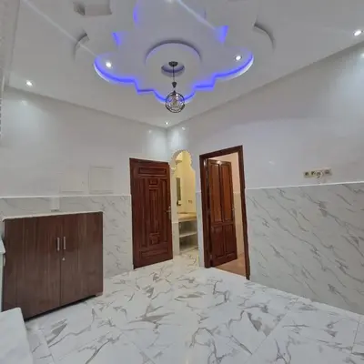 a room with a ceiling with a chandelier and two doors at Bel appartement de 2 chambres M in Marrakech