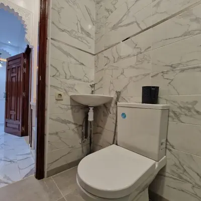 a bathroom with a white toilet and a sink at Bel appartement de 2 chambres M in Marrakech