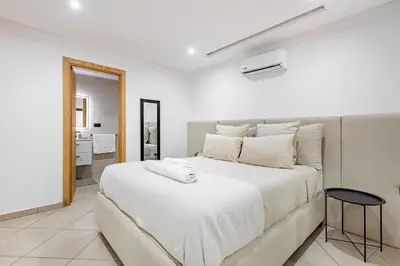 a bedroom with a large white bed and a mirror at New! Duplex de Luxe, Cocon de Confort in Marrakech