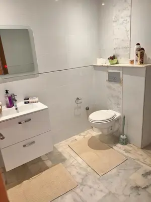 a white bathroom with a toilet and a sink at LUXURY APPART Pool view Riad Garden in Marrakech