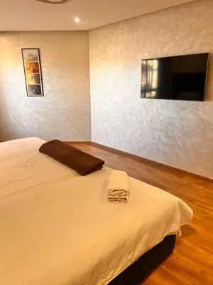 a bedroom with a bed with a flat screen tv at LUXURY APPART Pool view Riad Garden in Marrakech