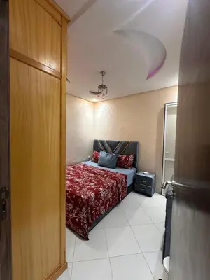 a bedroom with a bed with a red blanket at Charmant Appartement 2 Chambres pour Sejours en Famille Marrakech in Marrakech