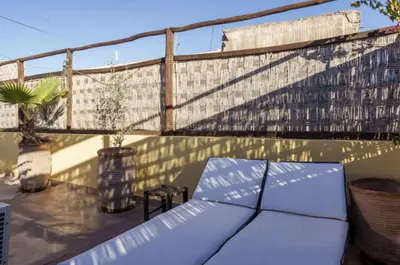 a rooftop patio with a bench and a fence at Riad Slima - riad privatisé -Marrakech au coeur de la médina 1 Acheminement compris Aéroport riad in Marrakech