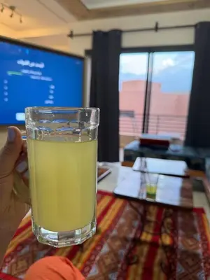 a person holding a glass of drink on a table at A1, Central, Old-City 7Min on feet, good equipped in Geliz, Bab-Dokala, Majorelle, No taxi needed in Marrakech