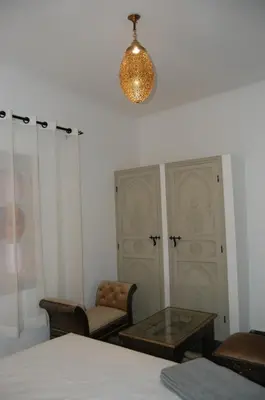a room with a table and chairs and a lamp at Riad Orient Palace in Marrakech