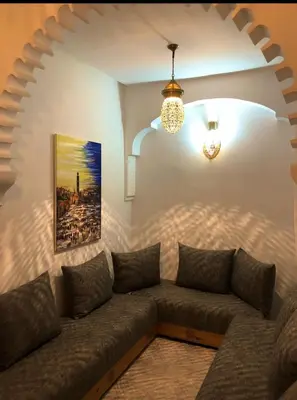 a living room with a couch and a chandelier at Riad Orient Palace in Marrakech
