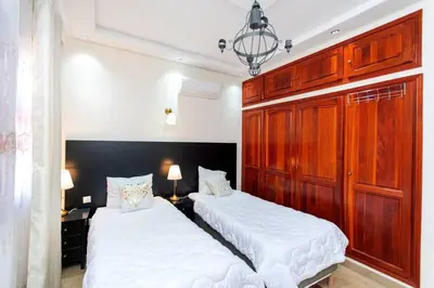 two beds in a room with white sheets at Zine Villa Guest House in Marrakech