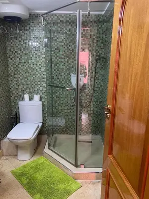 a bathroom with a glass shower with a toilet at Chez Alex in Marrakech