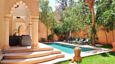 a backyard with a swimming pool and a house at Barthélemy Guest House in Marrakech