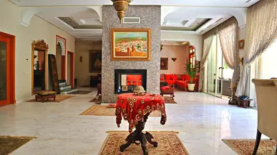 a living room with a table and a fireplace at Barthélemy Guest House in Marrakech