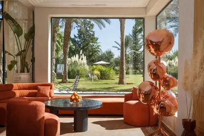 a living room with orange furniture and a large window at Maggy Rose in Marrakech