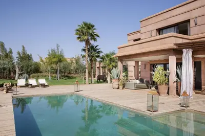 a house with a swimming pool in front of a house at Villa MISH-MISH in Marrakech