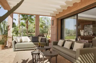 a living room with couches and tables and glass doors at Villa MISH-MISH in Marrakech
